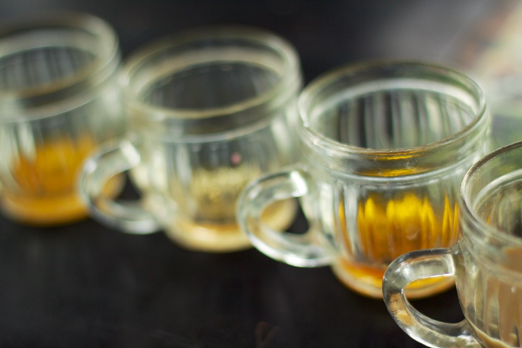 A row of glass cups of coffees and herbal teas