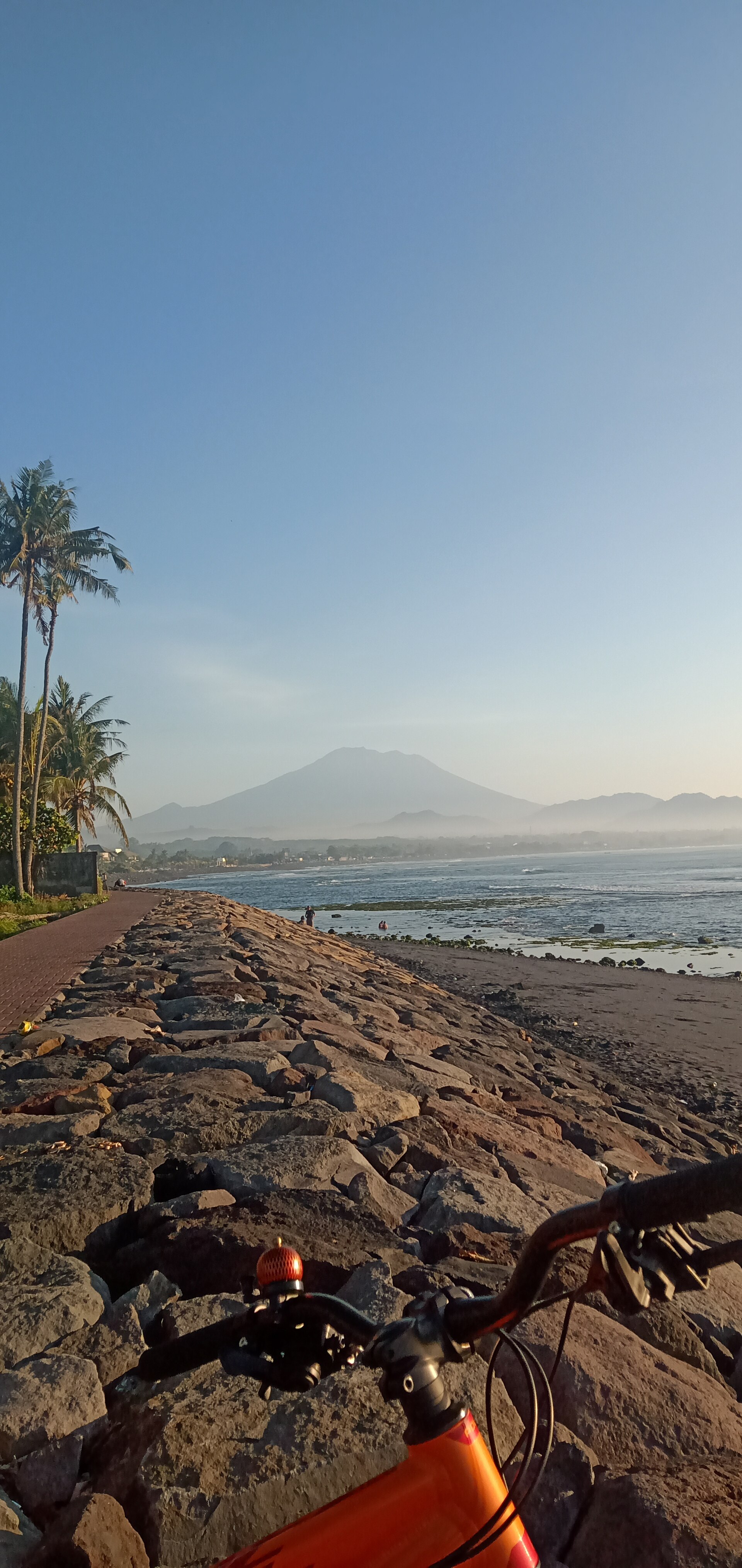 A bicycle on a coastal path with Mount Agung beyond
