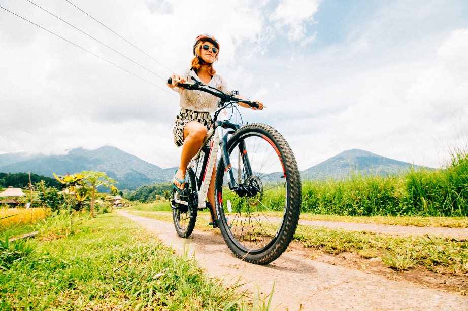 A woman on an e-bike riding through the Jatiluwih rice terraces