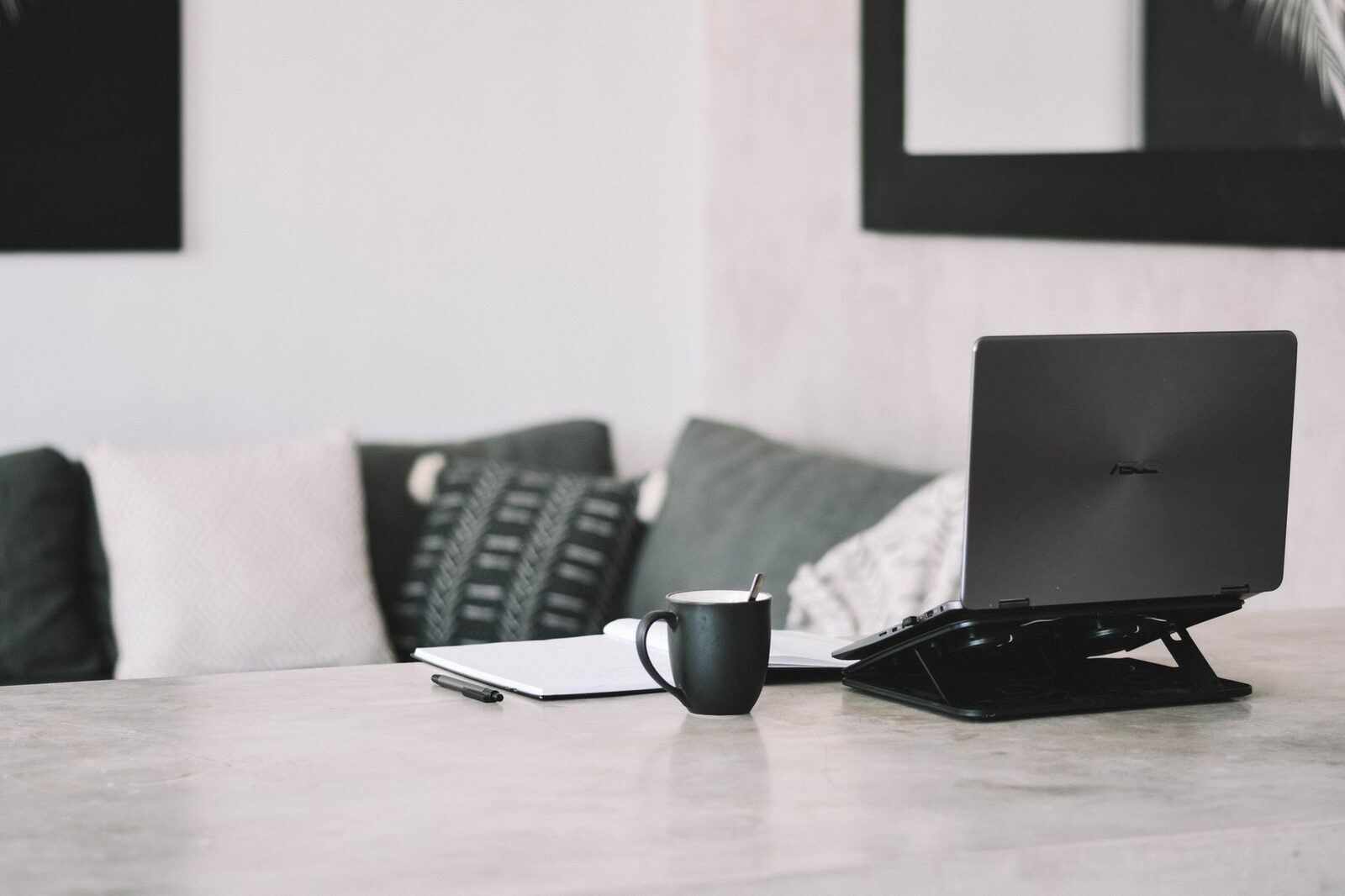 A laptop on a stand with a mug — the portable office most nomads carry.