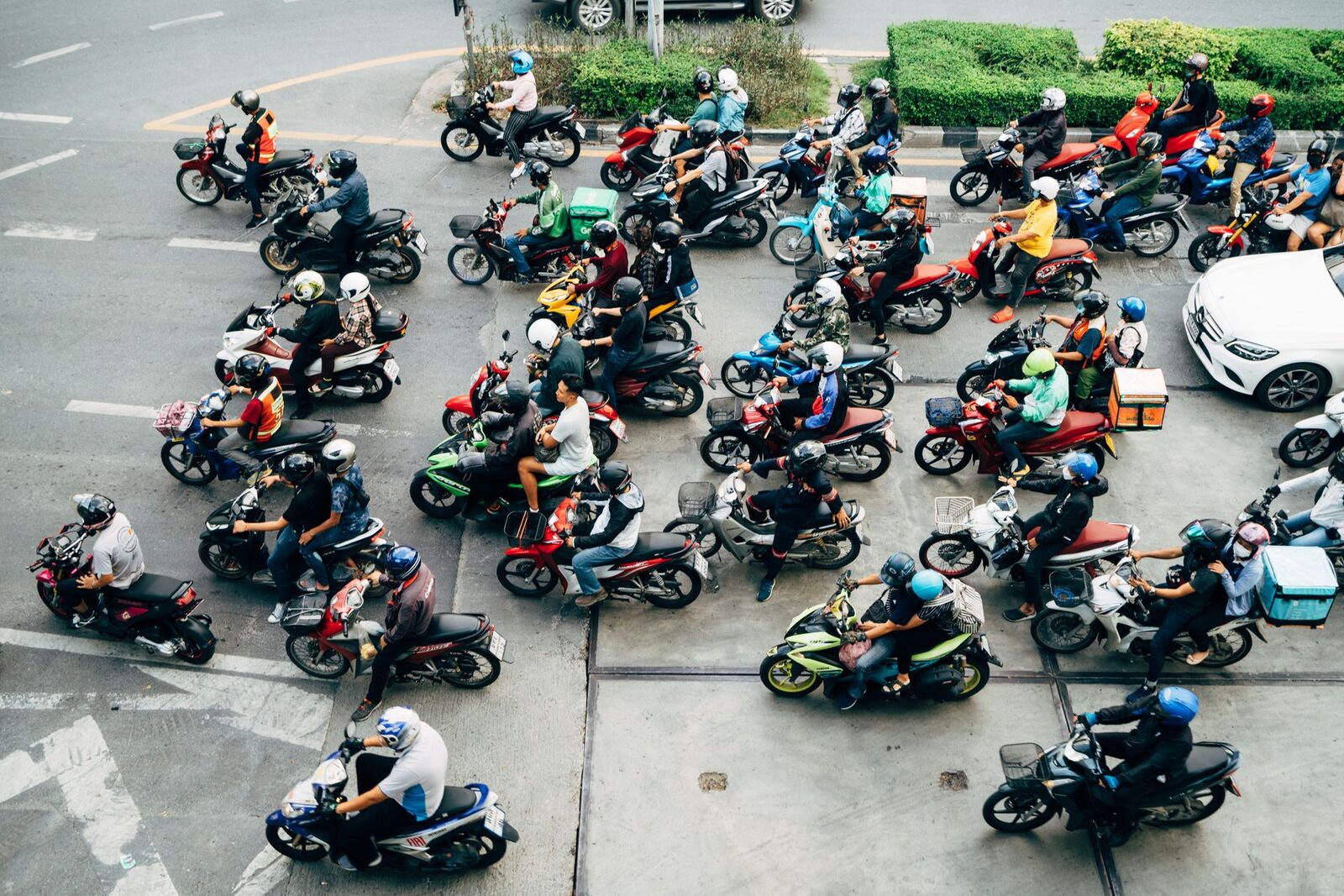 An intersection swarmed with scooters from above — Bali traffic at full tilt.