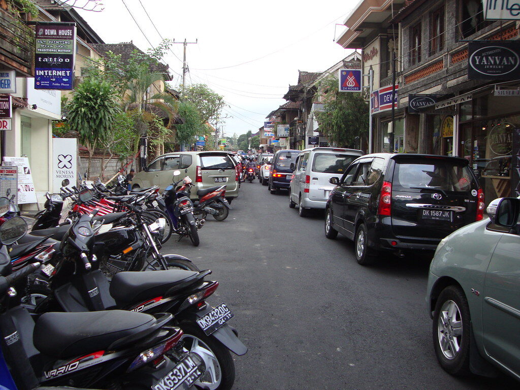 The downside nobody posts — a Bali street jammed with cars and scooters, the congestion that's bad and getting worse.