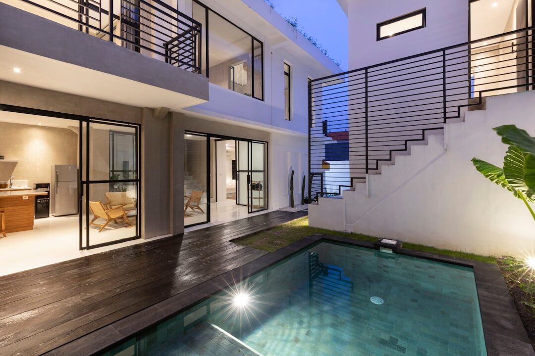 A modern villa at dusk, pool lit — what 'comfortable' looks like on the listings.