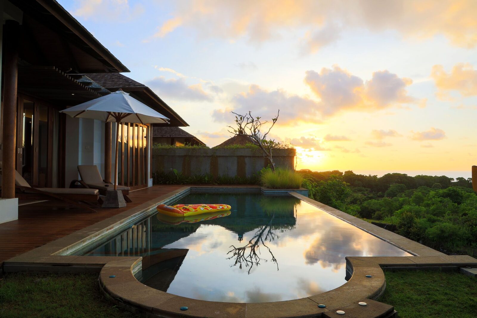 Sunset over a villa pool and pavilion — the photo that sells the month.