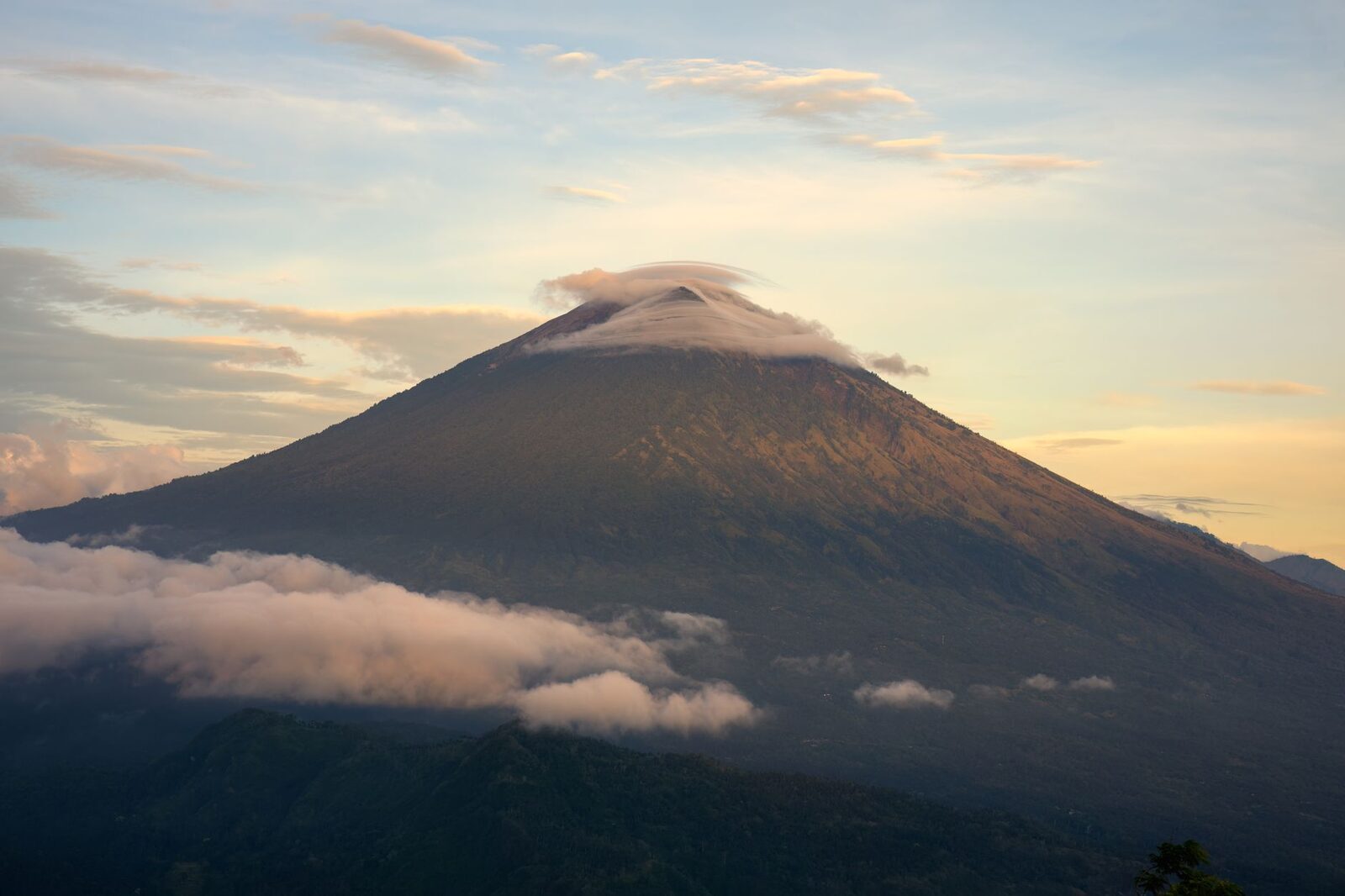 Mount Agung above a sea of cloud at first light — Bali's highest peak, and the pole the whole east orients toward.