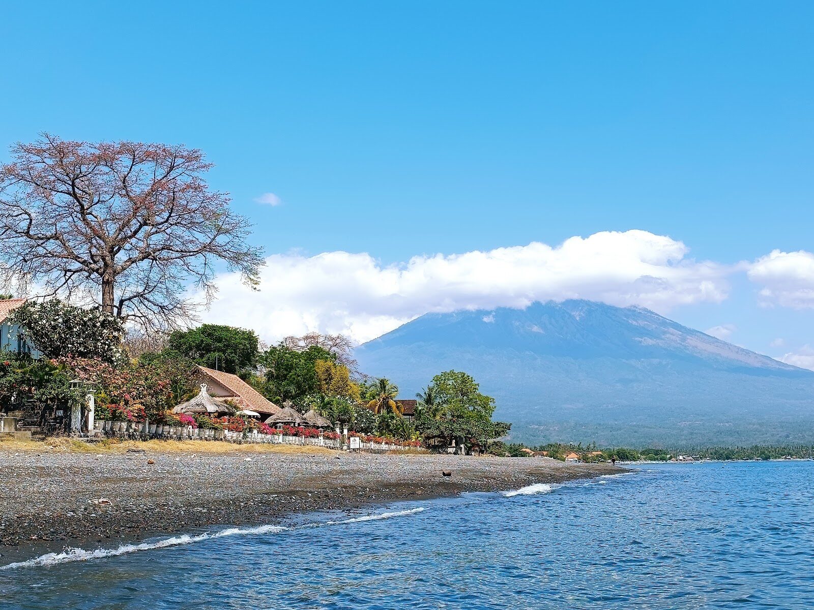 Black-sand beach with Agung rising across the water.