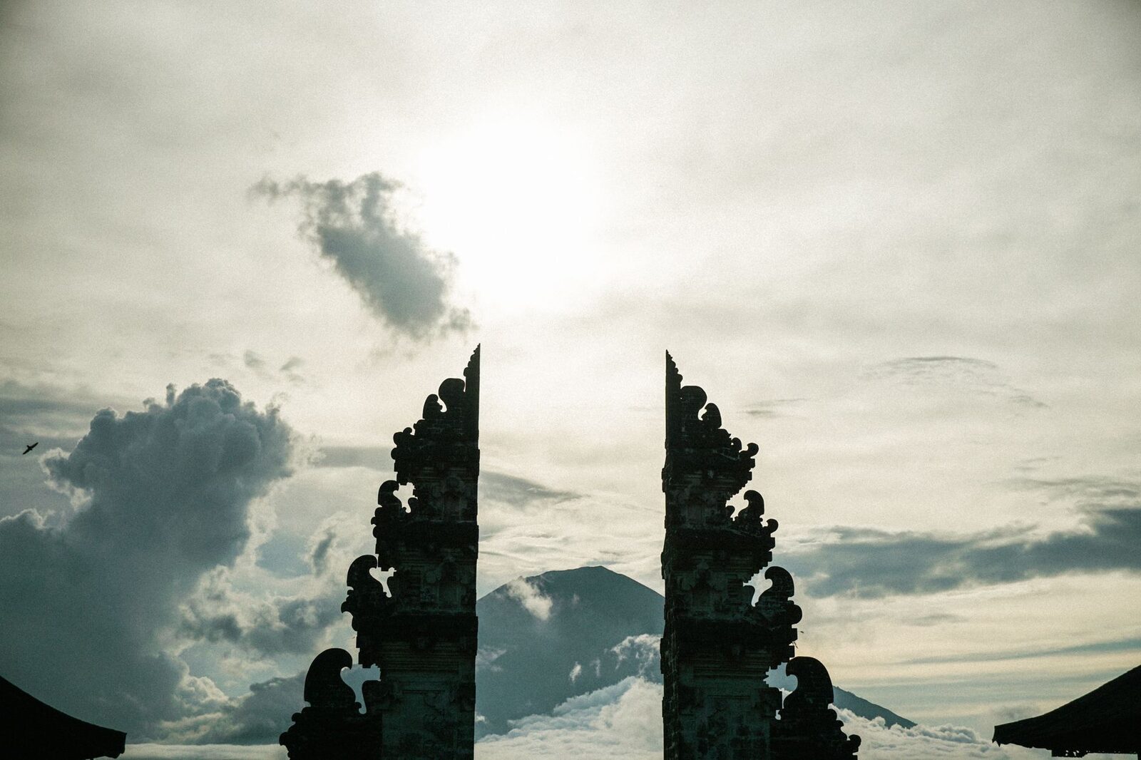 The gates in silhouette at dusk, Agung's ridgeline behind.