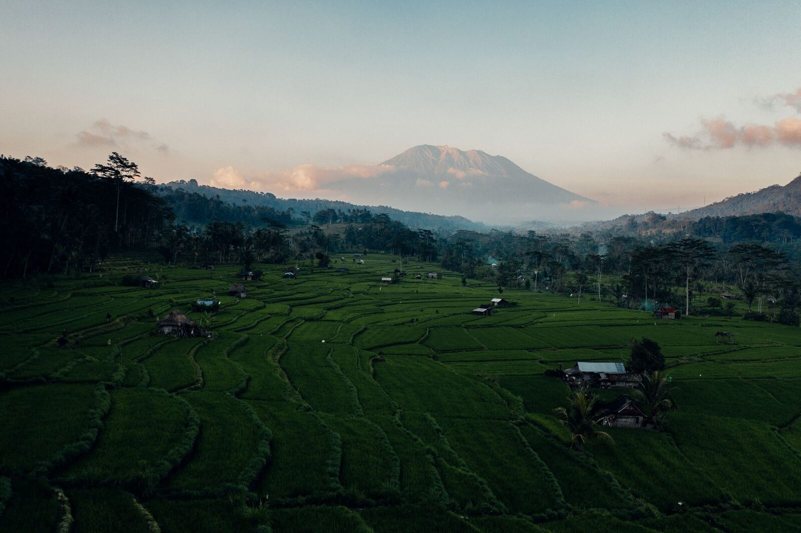 Sidemen at dawn — rice terraces stepping down a quiet valley with Mount Agung behind. The slow, green east that people wrongly imagine Ubud still is.