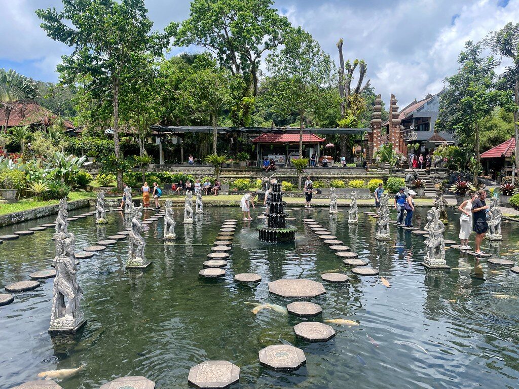 Visitors wading the pond on the stepping stones at midday.