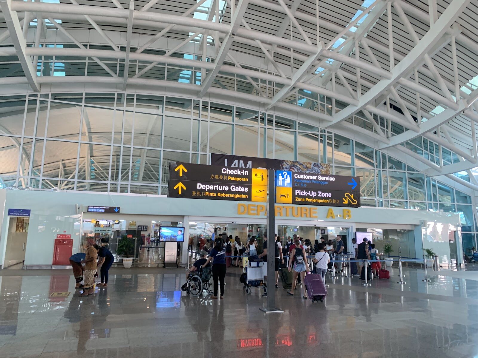 Inside the DPS terminal, travellers moving through the bright departures hall.