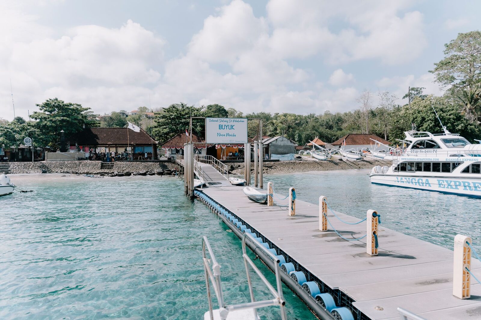 A fast boat waiting at the jetty over clear turquoise water, ready to load.