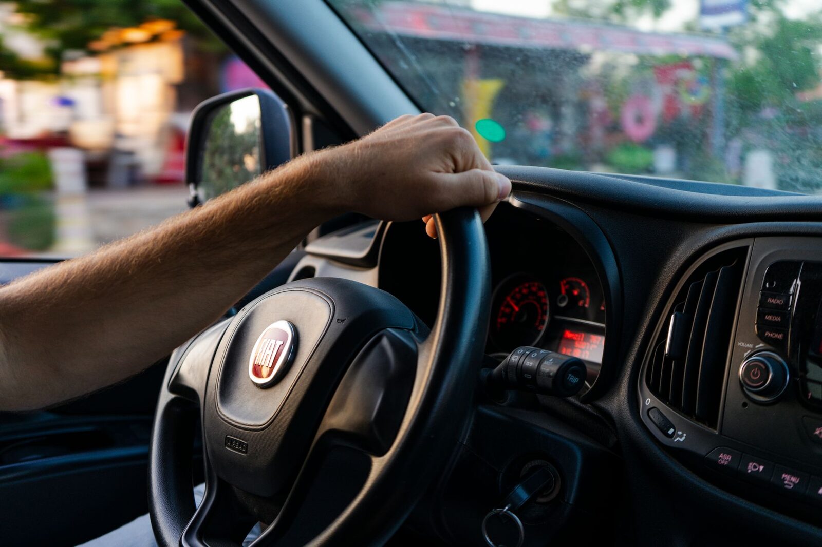 Driving a guest through town, the shopfronts sliding past the windscreen.
