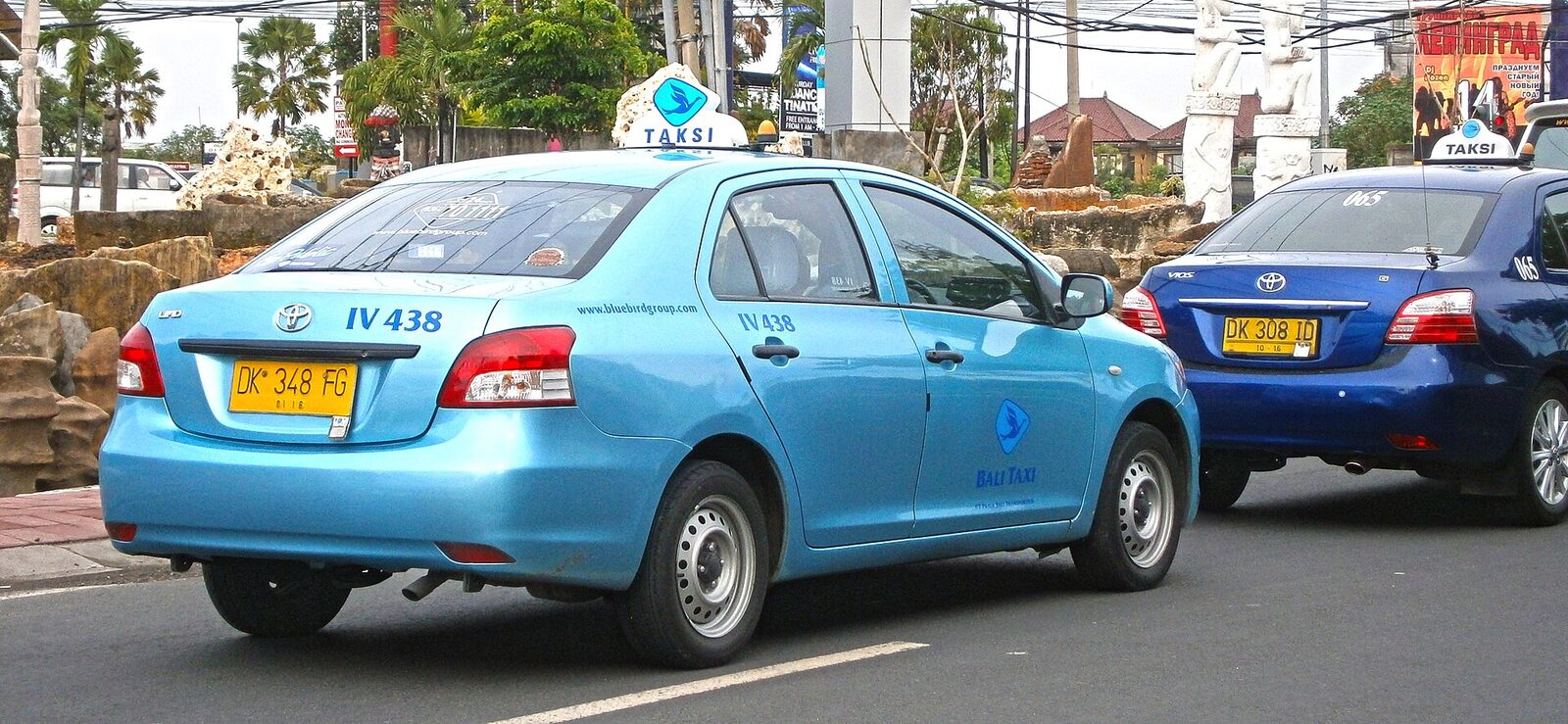 The blue metered taxi from behind, the roof light and bird logo visible.