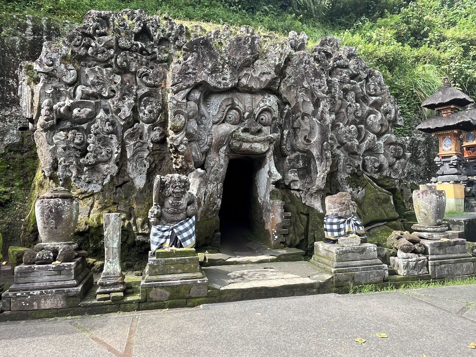 The full facade with its two stone guardians standing watch at the door.