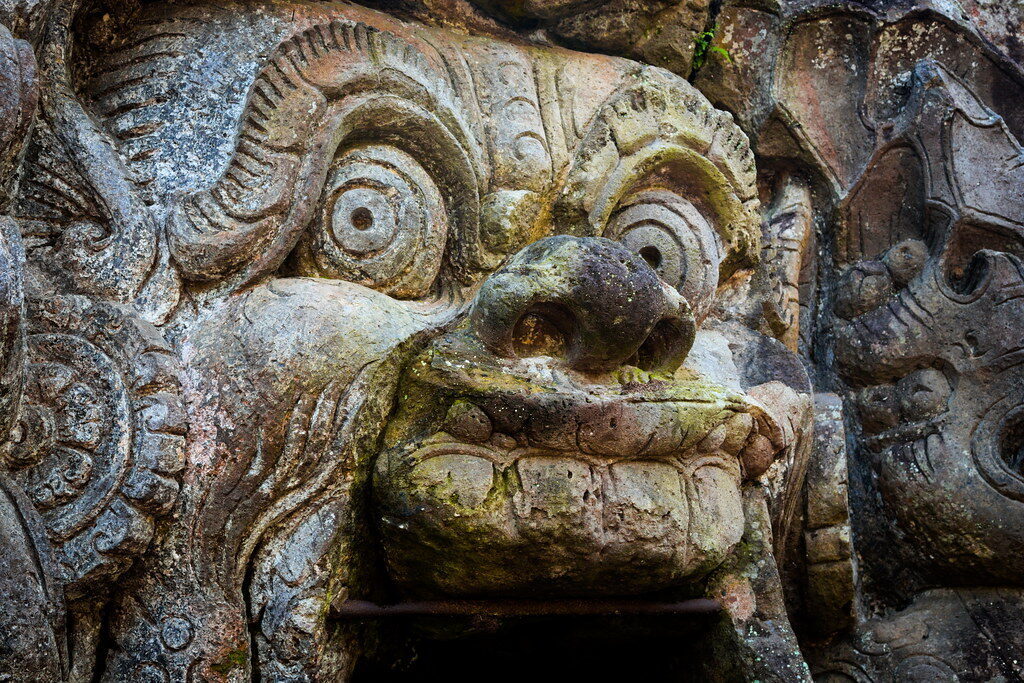 A tight crop on the weathered face carved over the doorway.