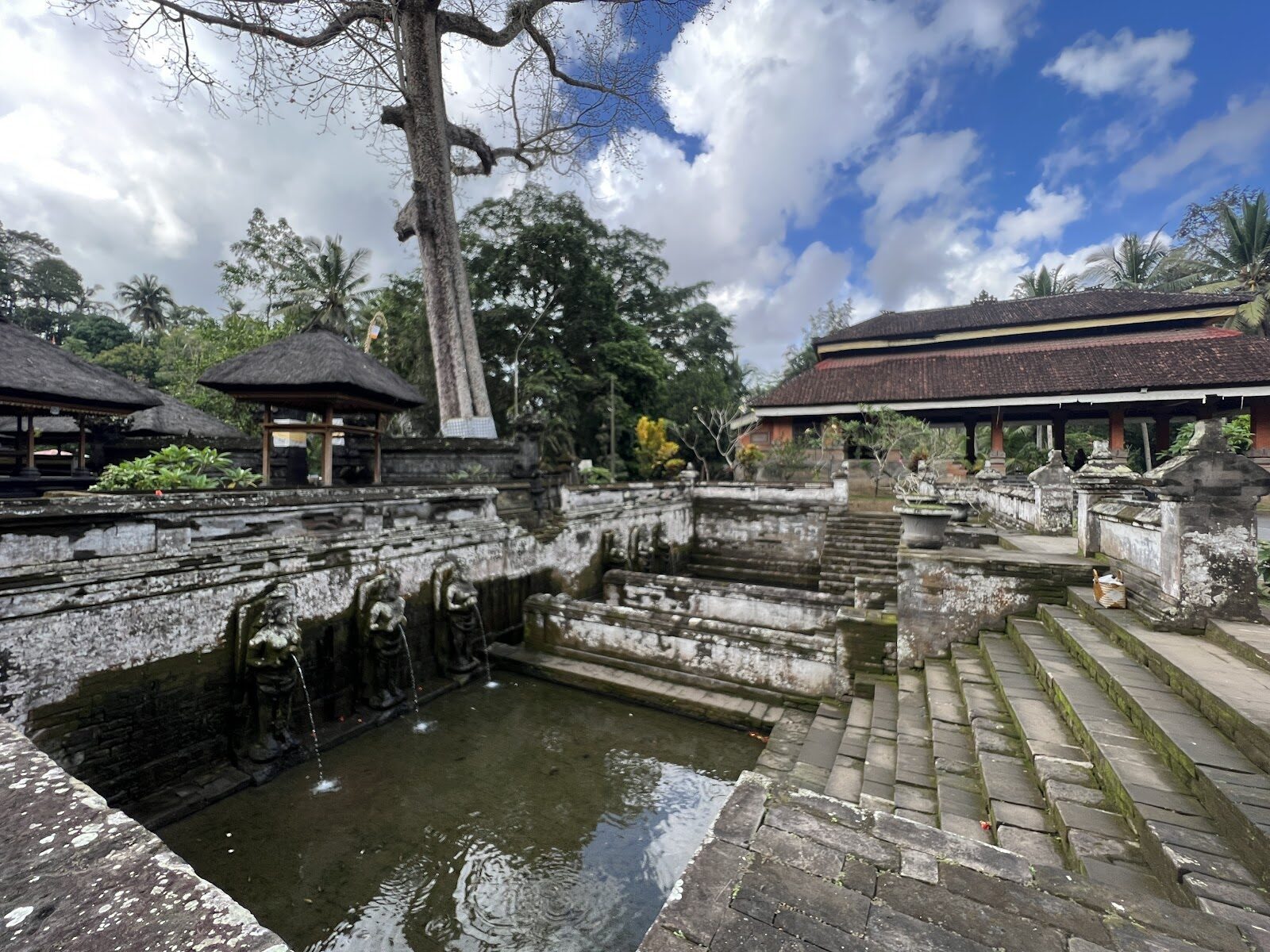 The rectangular bathing pool and its steps, tucked into the grounds below the cave.