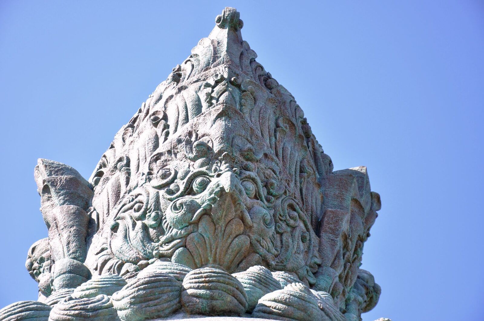 A close look at the carved stonework at the statue's base.