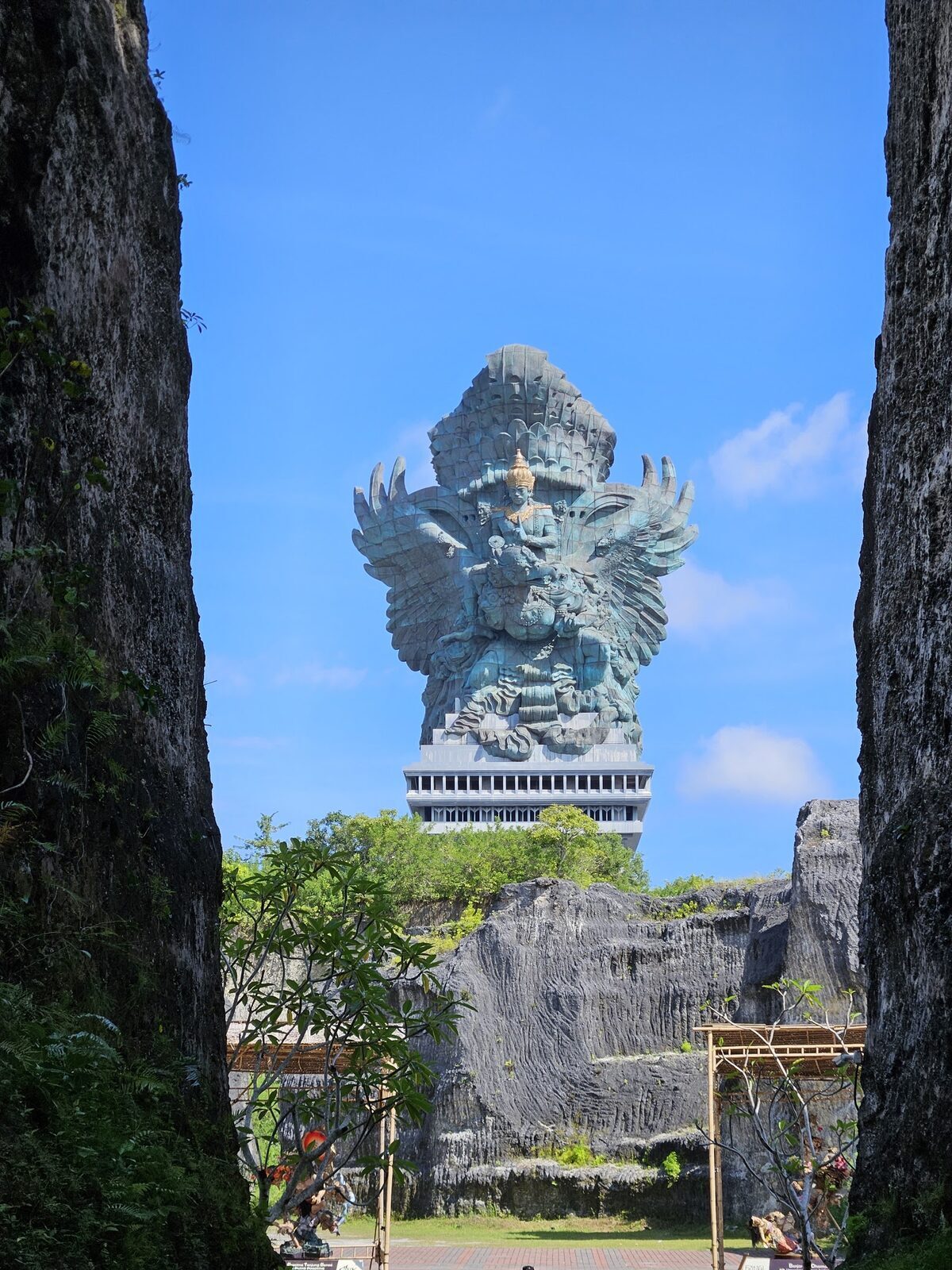 The statue framed in the gap between two sawn limestone walls — the park's signature shot.