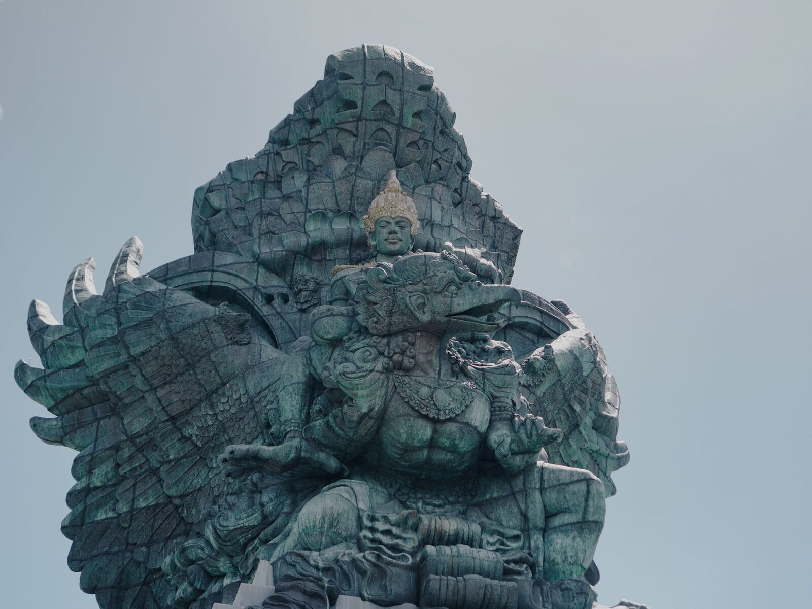 The god riding the Garuda, seen close — the detail in the eagle's plumage and the god's ornament.