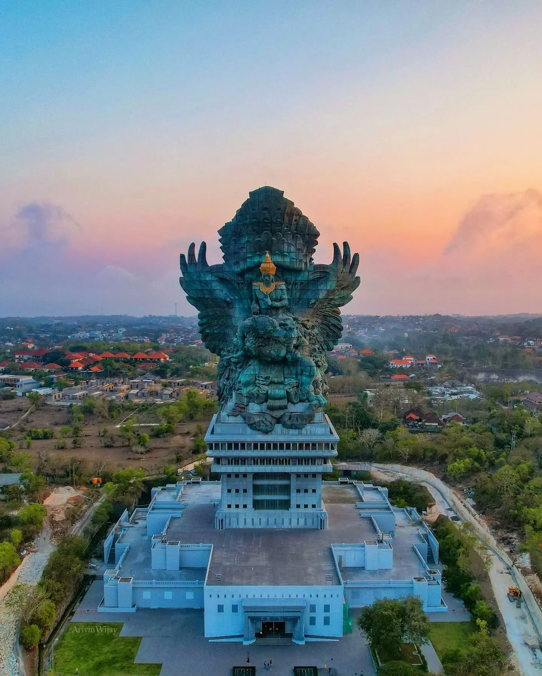 The completed 121-metre statue at dusk, rising from its plinth over the plateau — Vishnu astride the Garuda.