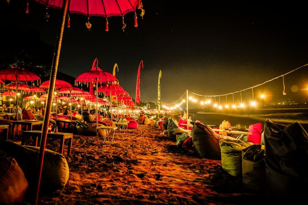 The beachfront warungs at night, lit by lanterns and strings of bulbs on the sand.