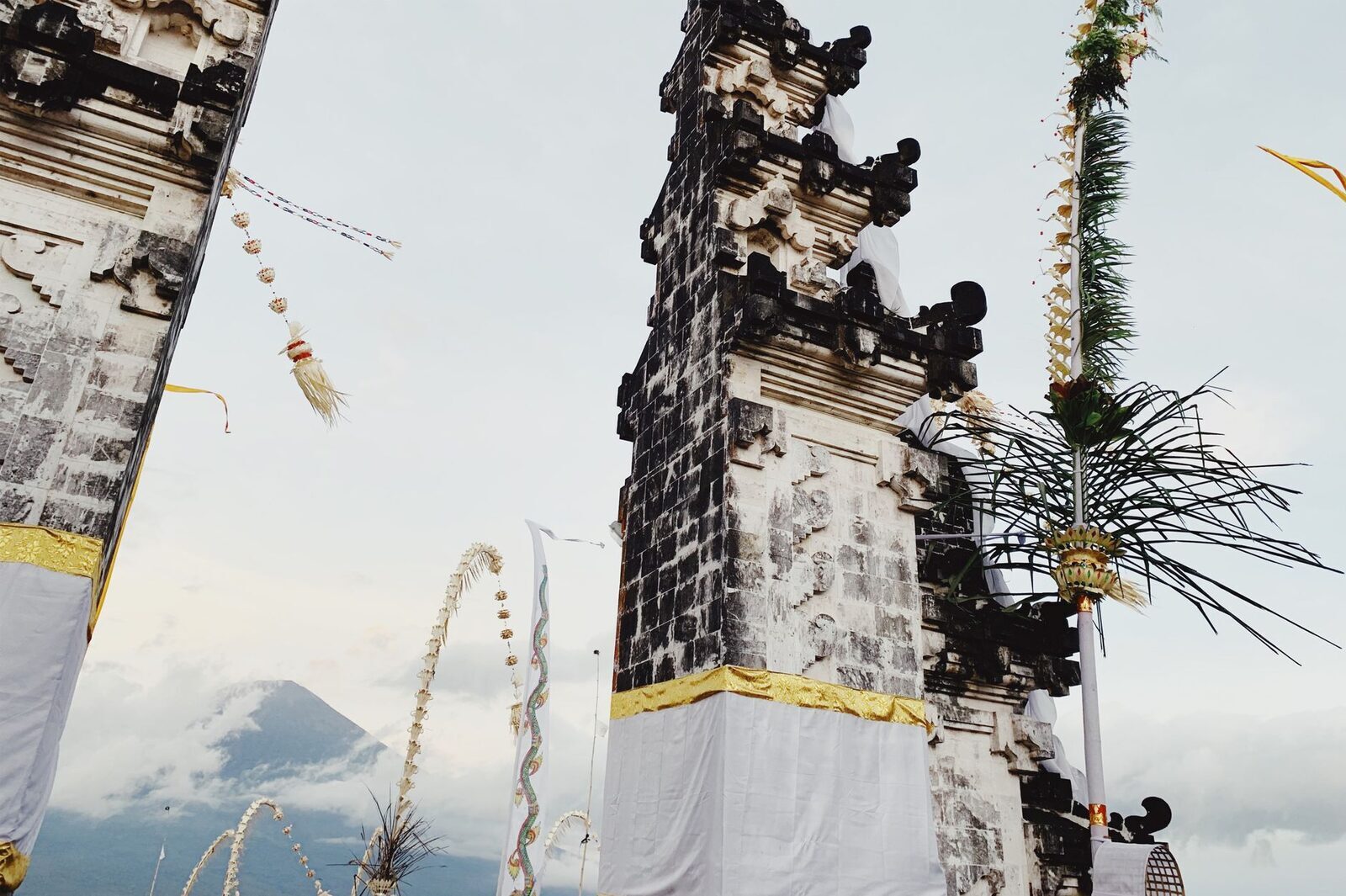 The temple gates with Mount Agung framed beyond, wreathed in cloud.