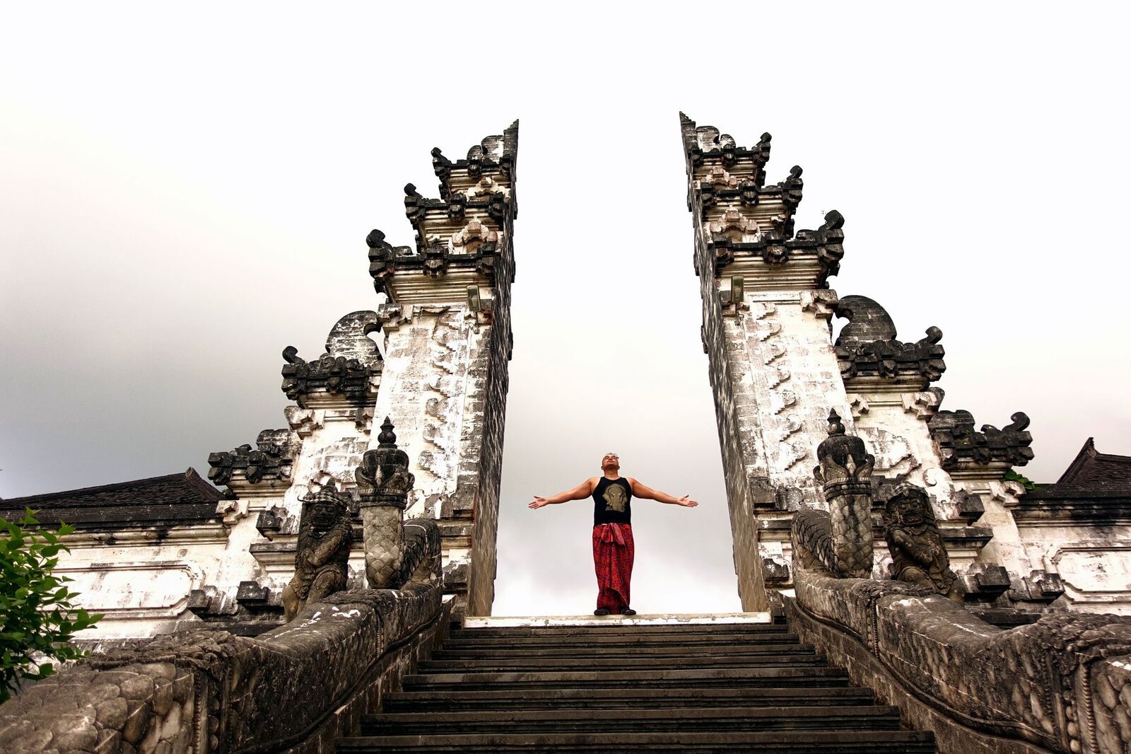 One person at a time steps up for the arms-wide pose — the queue moves in single shots, like a production line.