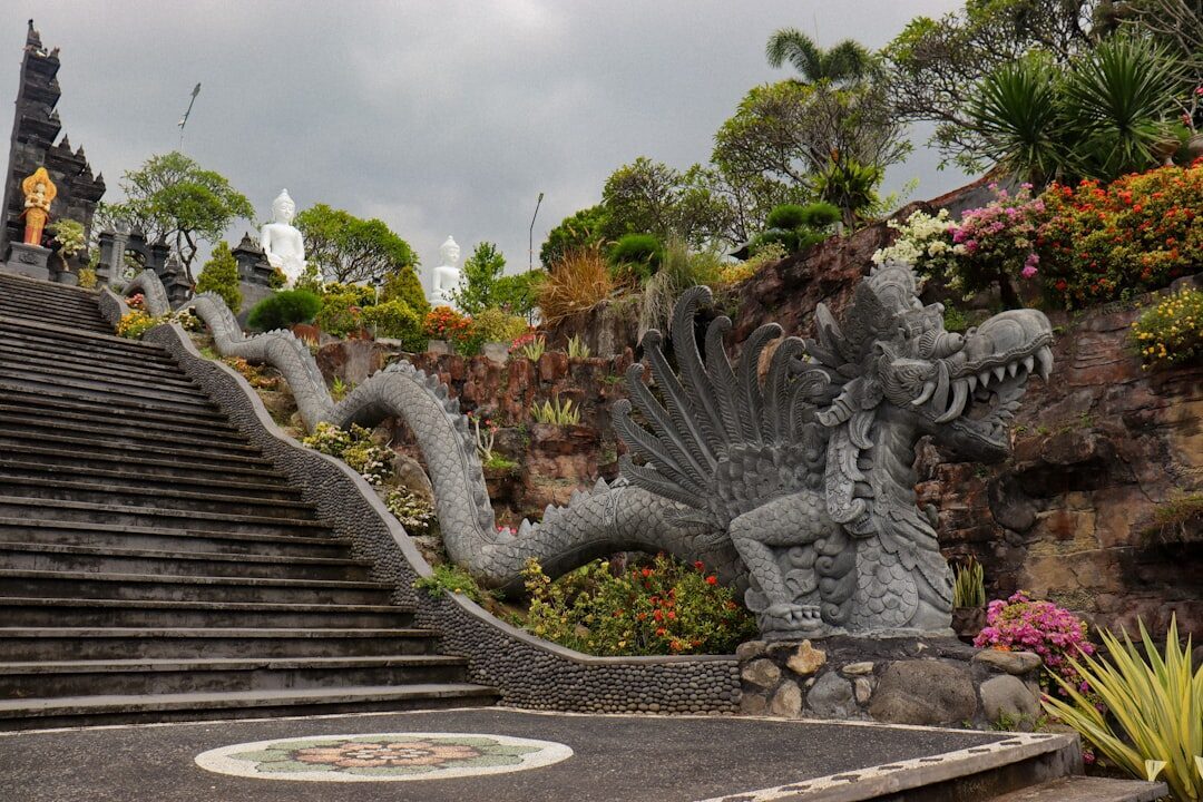 Dragon balustrades flank the stone steps as they climb the mountainside through the temple gardens.
