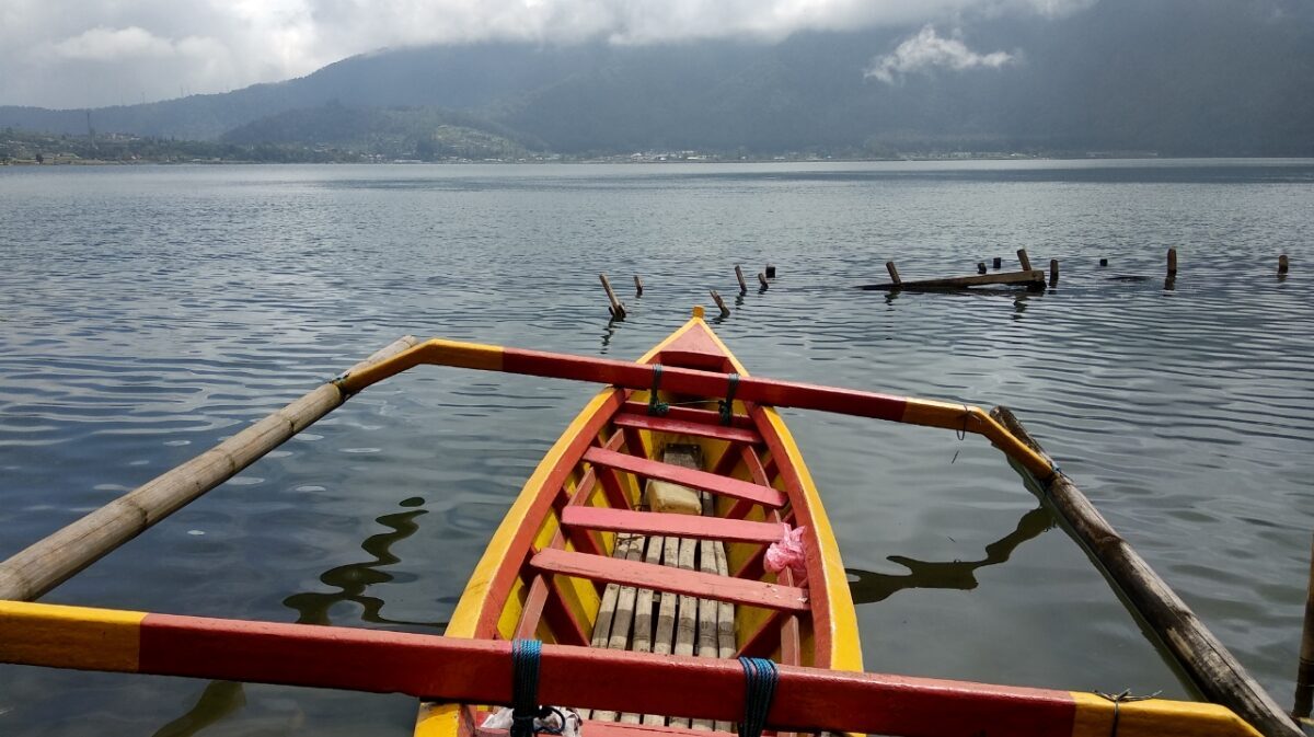 An outrigger's-eye view across a still Bedugul lake.