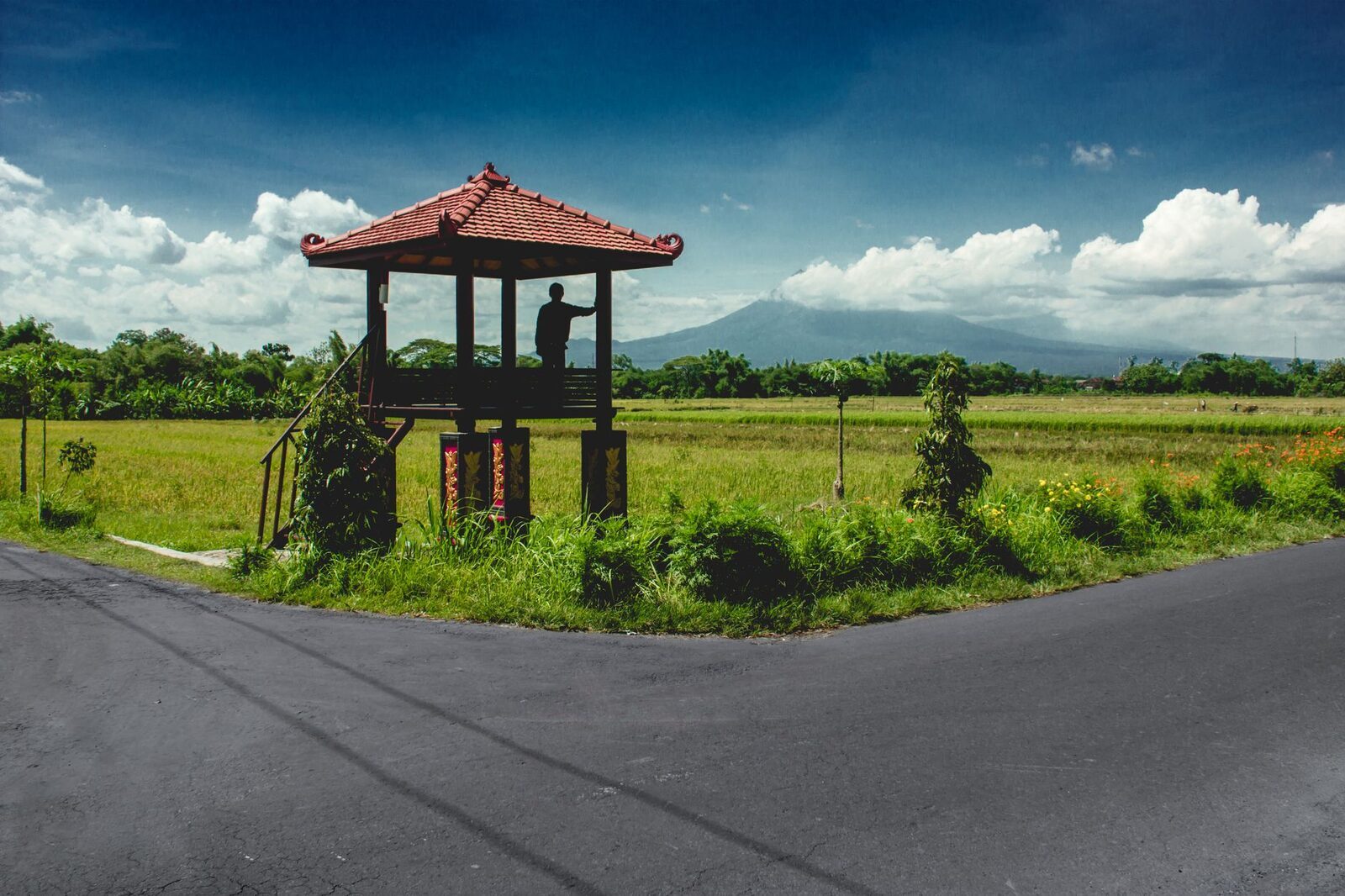 A roadside shrine above the rice fields — the highland country the drive threads through.