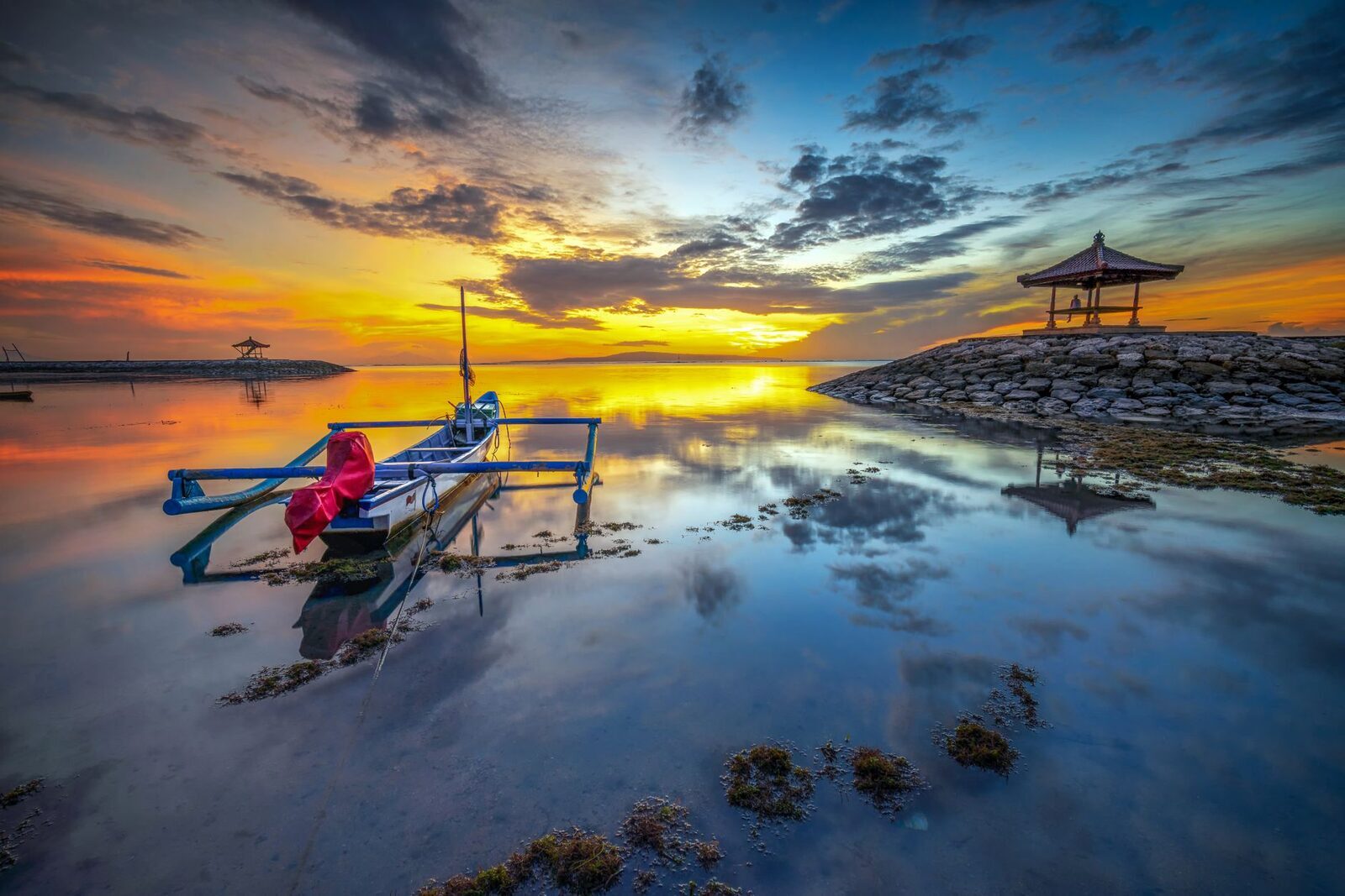 A traditional jukung outrigger at first light — the kind of chartered boat that makes the crossing.
