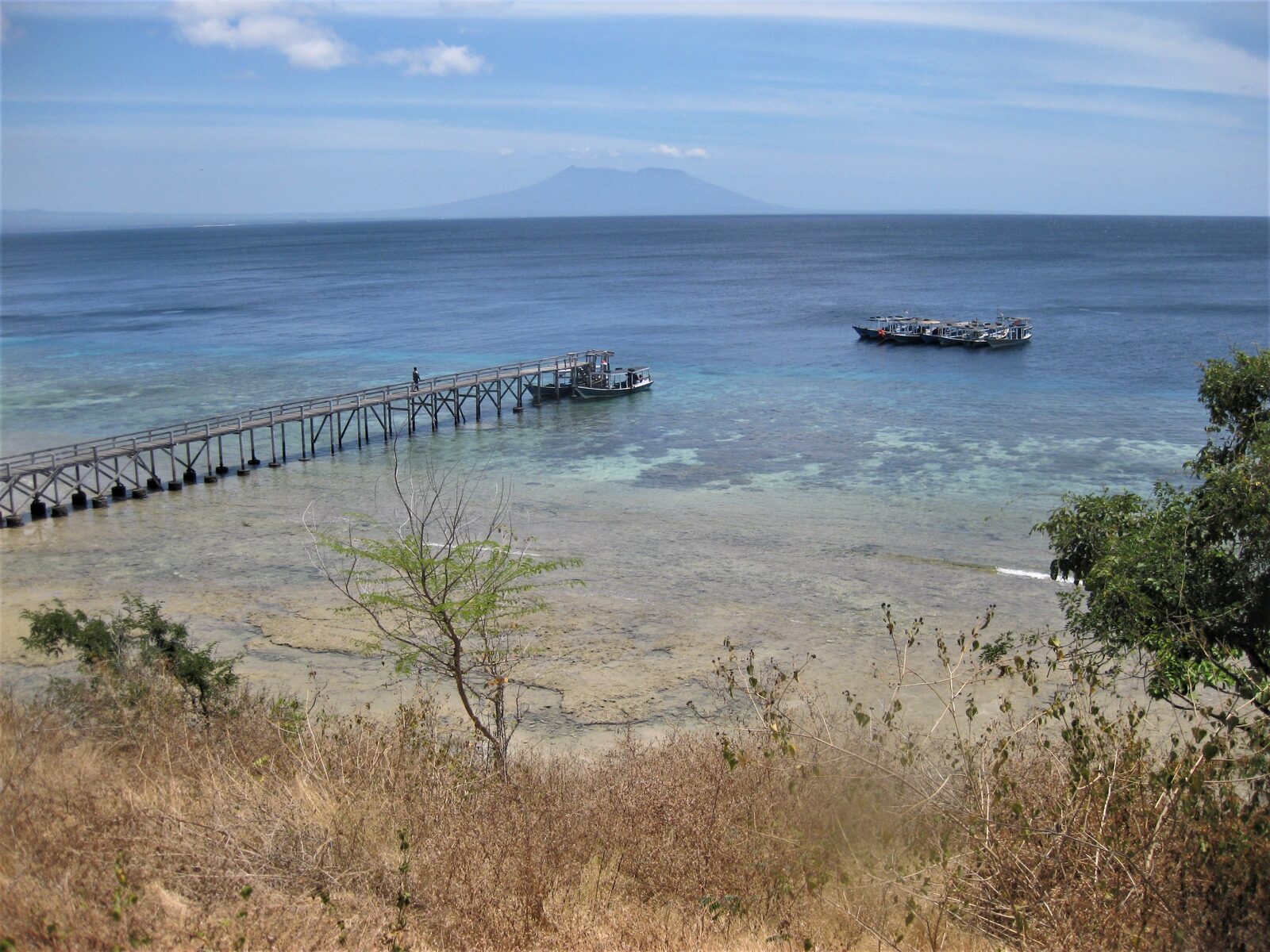 A jetty running out over the reef, the coast of Java hazy across the strait.