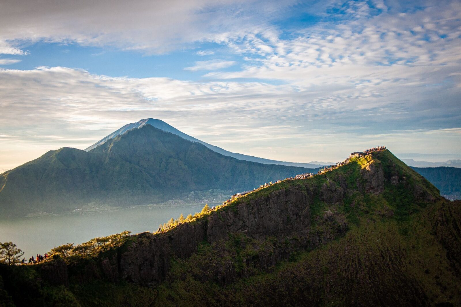 Trekkers on Batur's rim at first light, the bigger peaks behind.