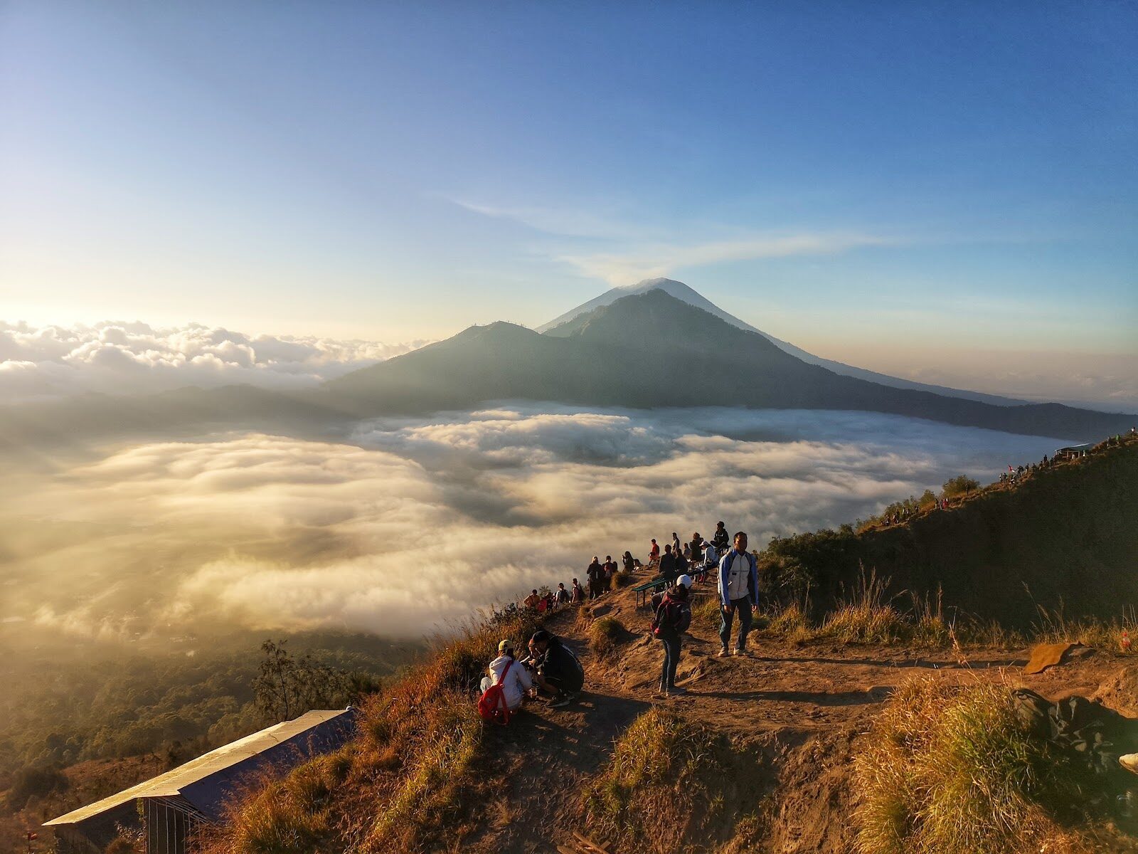 The easier alternative: a line of hikers on Mount Batur's summit trail at dawn. About two hours up, and doable for most reasonably fit people.