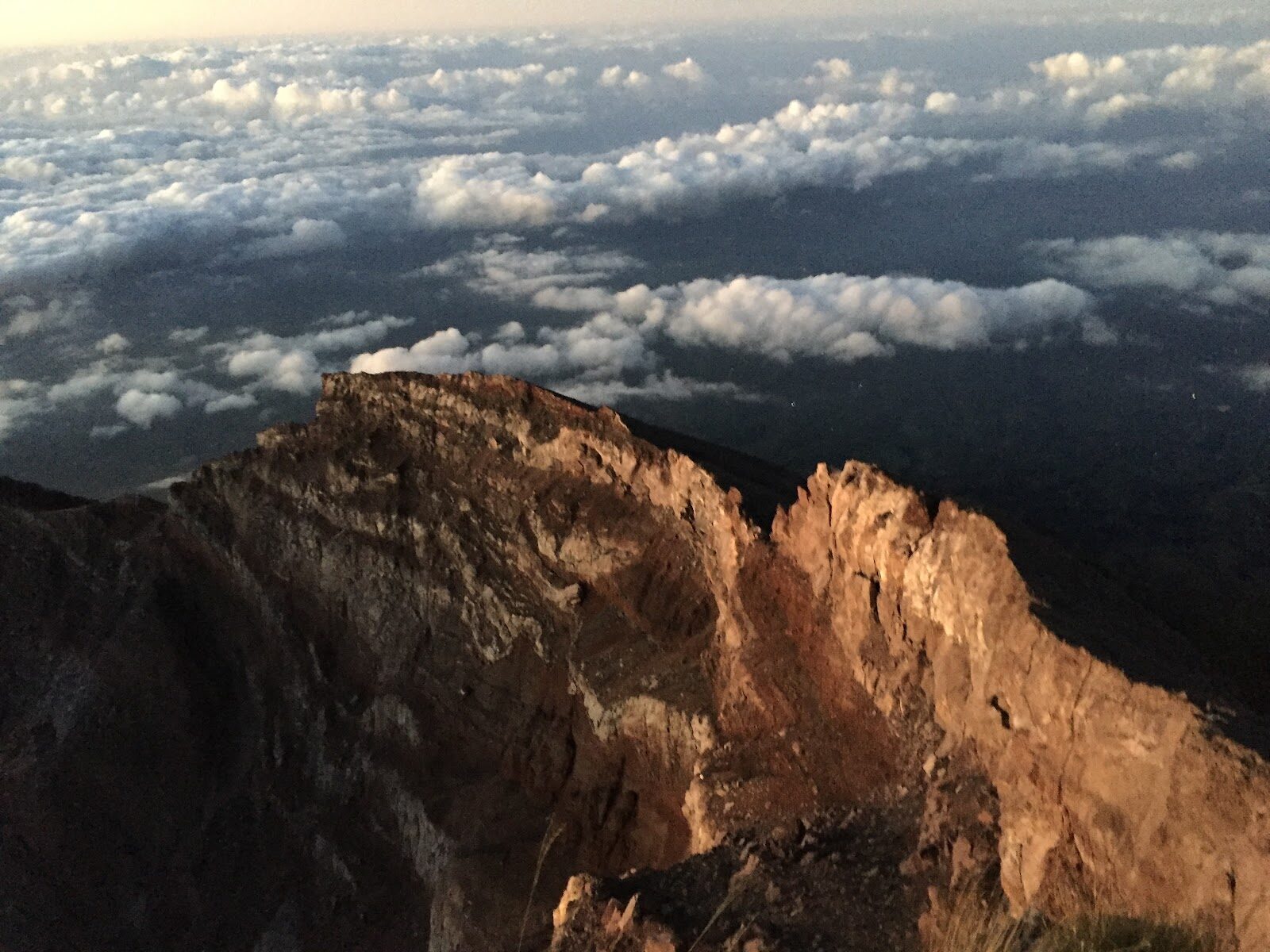 Cloud pouring over the summit rim at dawn.