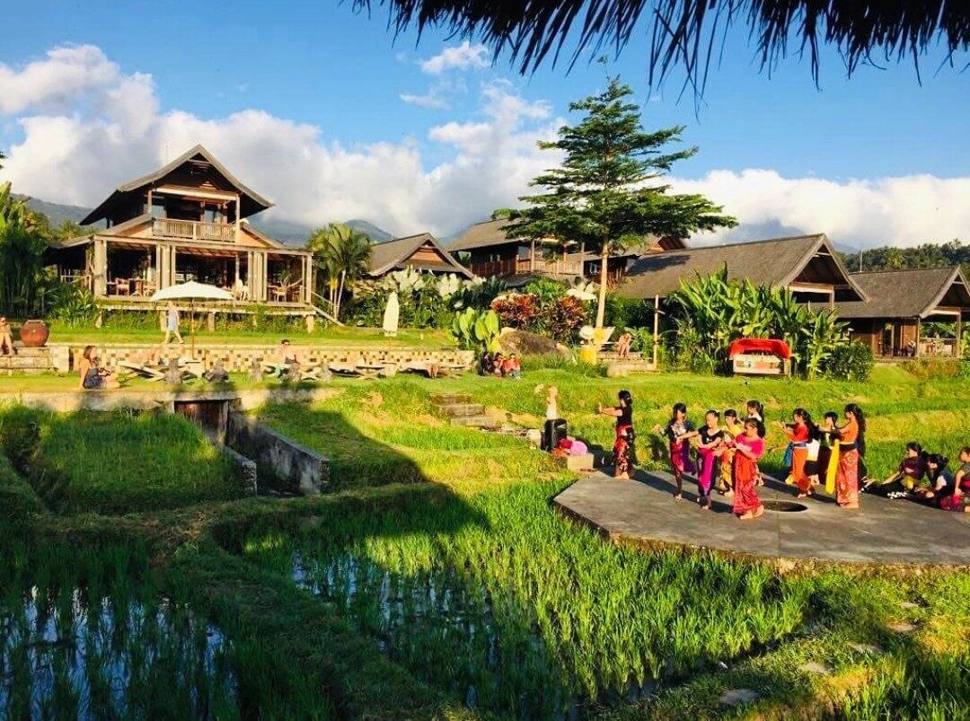 The uplands keep their old rhythms — villagers gathered in ceremonial dress by the paddies.