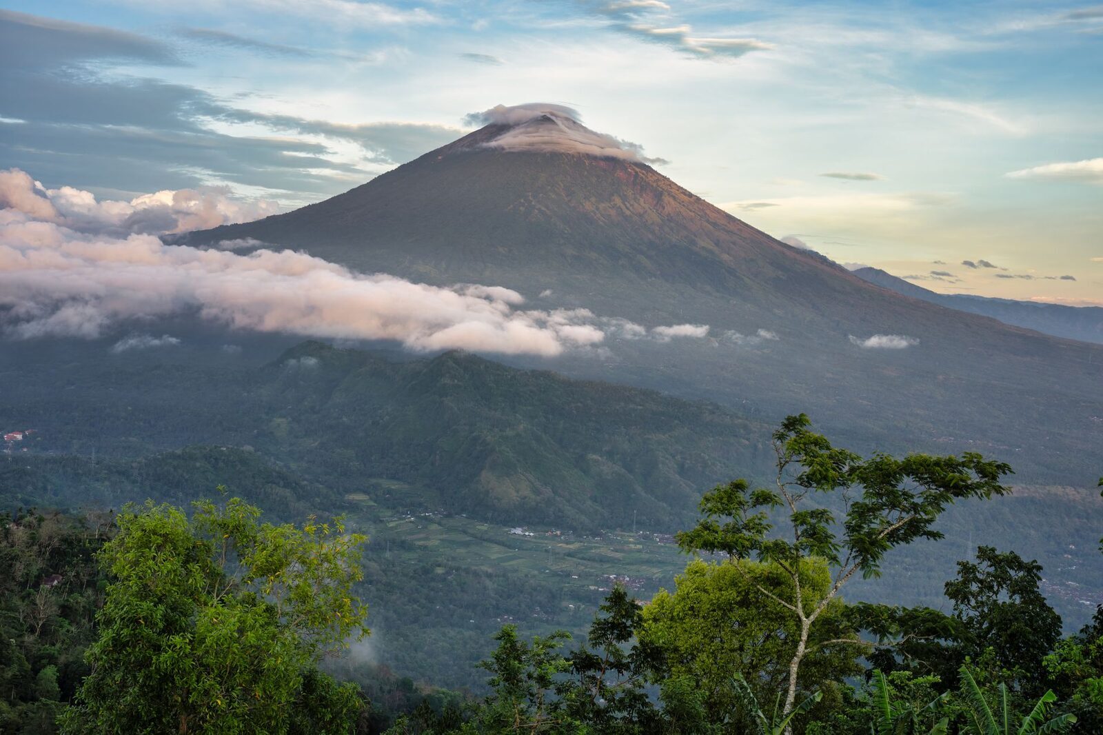 A central volcano rising above the forest at dawn — the high country between south Bali and the north coast.