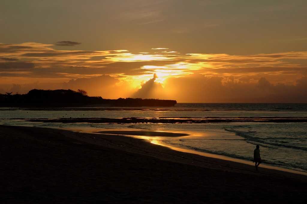 Dawn over the exposed reef flats — at low tide the water pulls back and the shallows turn rocky, so time a swim for mid-to-high tide.
