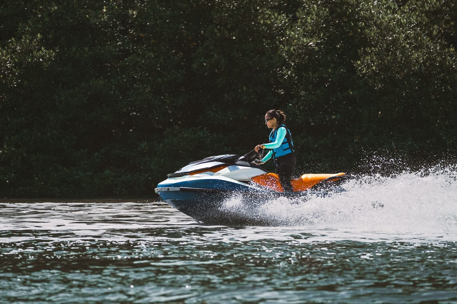 A jet-ski throwing spray on the flat water — beginner-friendly because the bay stays calm.