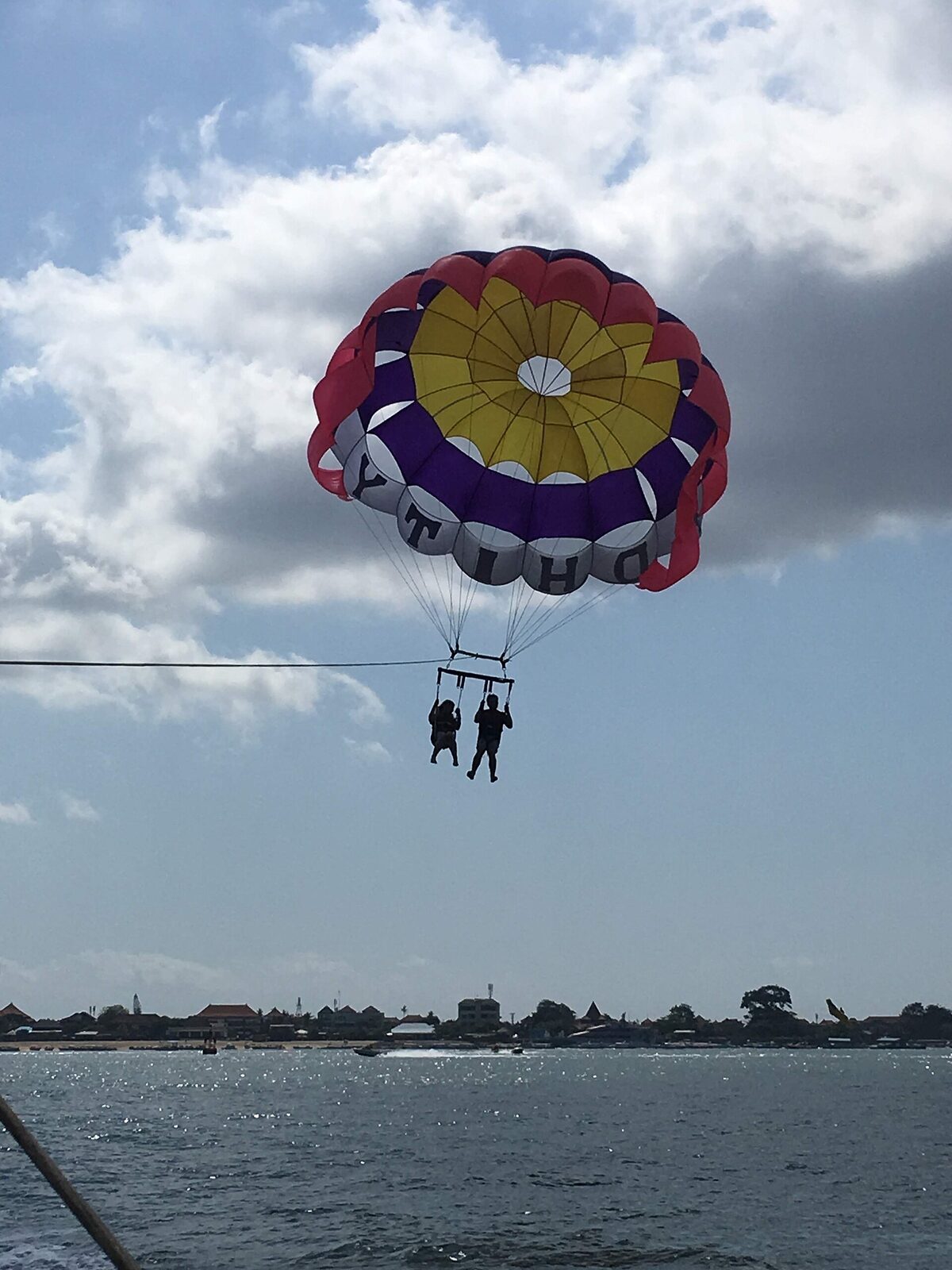 Parasailing over Tanjung Benoa — the strip's signature activity, launched off the calm bay.