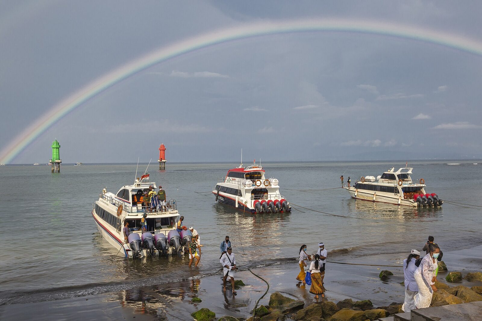 Fast boats lined up for a beach-launch at Sanur — passengers wade out to board, so pack valuables in a dry bag.