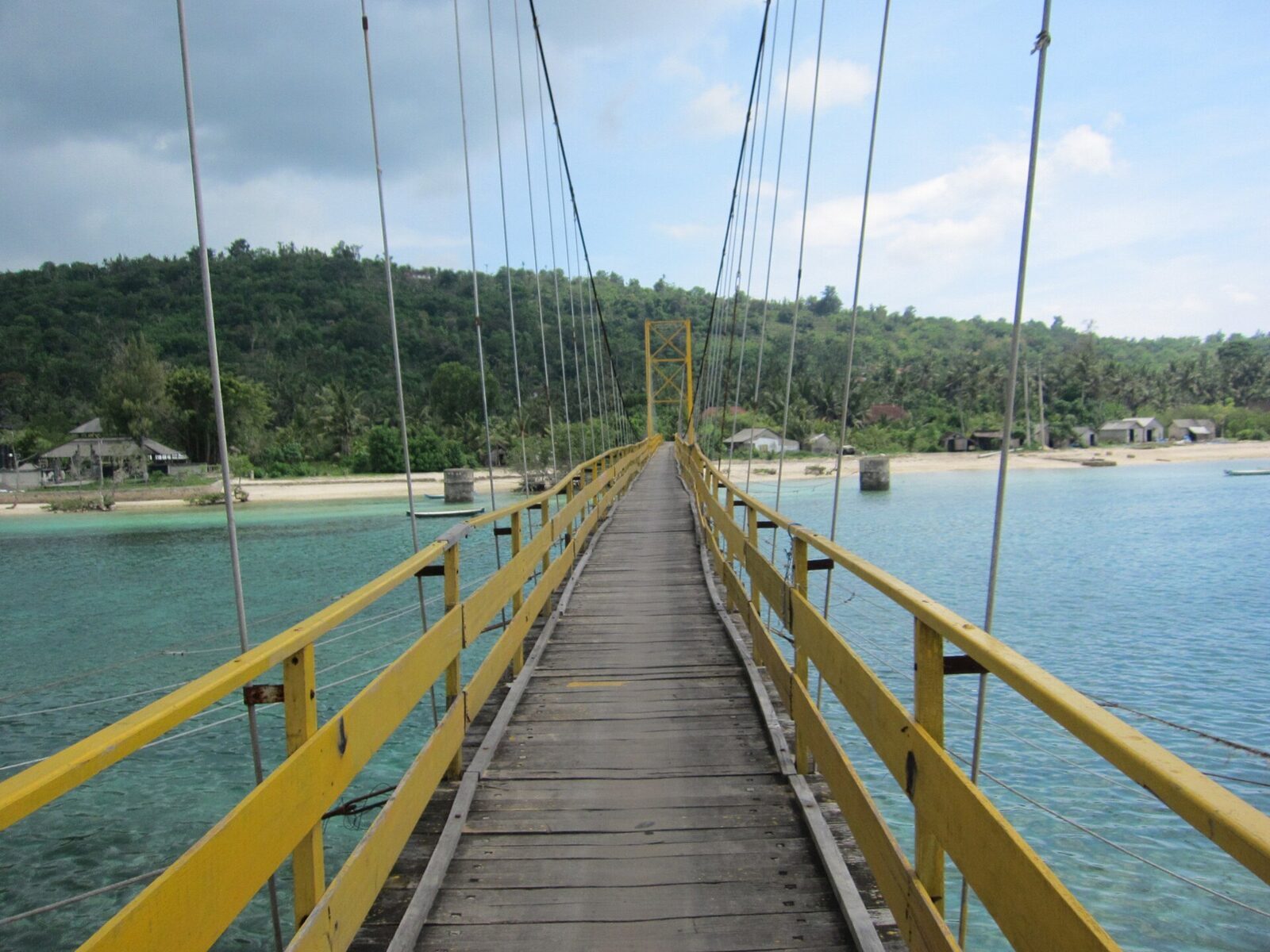 Walking the wooden deck of the yellow bridge across to Ceningan.