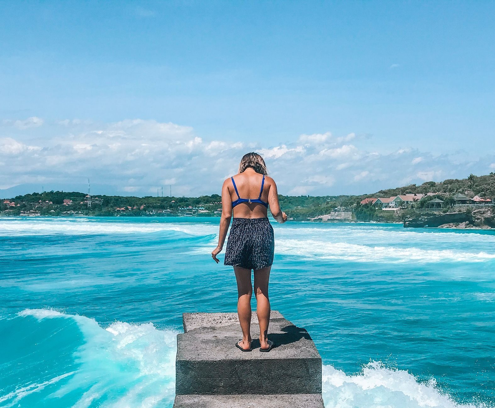 A visitor on a jetty looking out over the water at Lembongan.