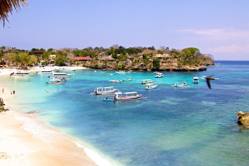 The arrival beach, dozens of boats moored on the turquoise shallows.