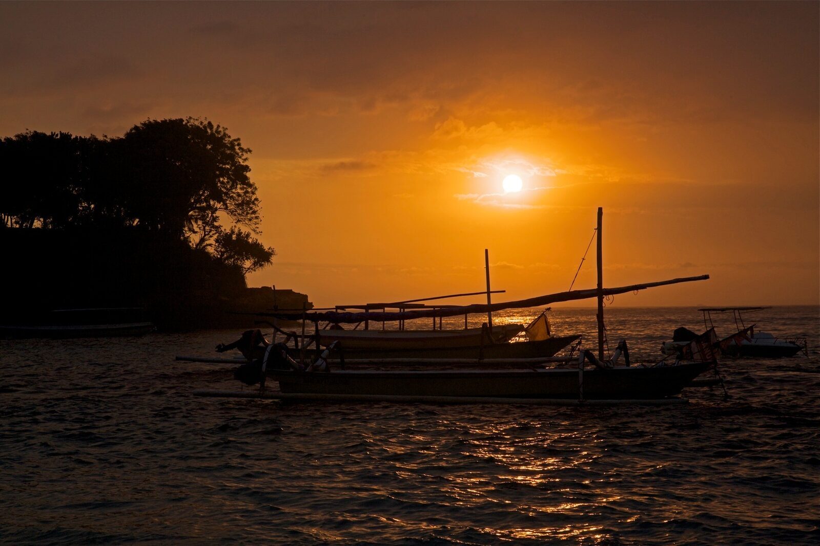A jukung outrigger silhouetted at sunset off Lembongan.