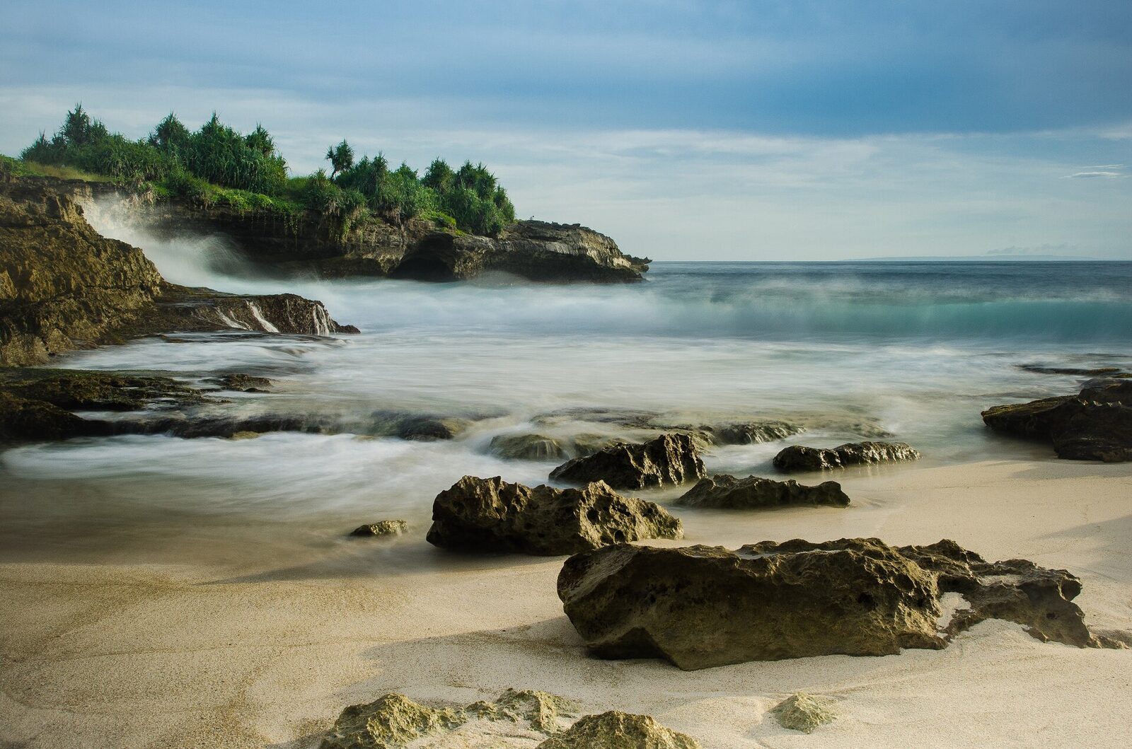 The rocky cove and small boats along the Dream Beach shore.