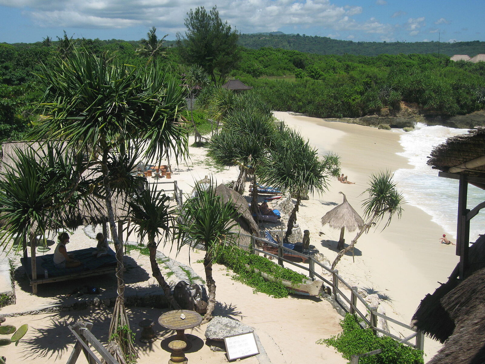 A quiet white-sand cove ringed by pandanus — the mellow side of the Nusa islands.