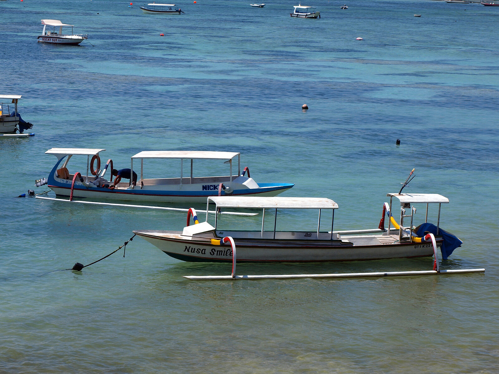 Traditional jukung outriggers anchored in the shallows off Lembongan.