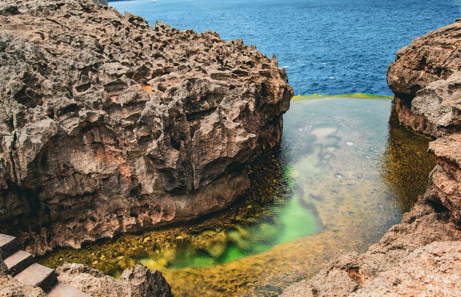 The Billabong pool tucked beneath its rock overhang, the ocean pressing just beyond the lip.