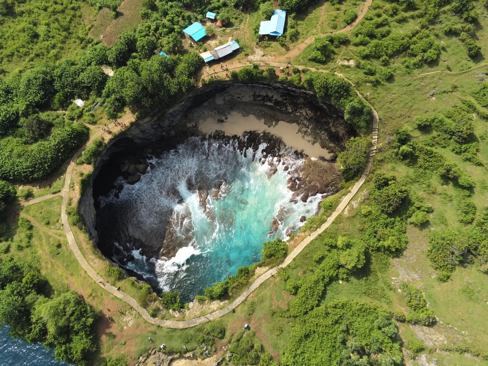 The near-perfect ring of Broken Beach from directly above, the sea entering through the arch.